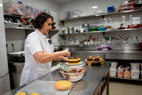Mariana decorando un pastel en el obrador